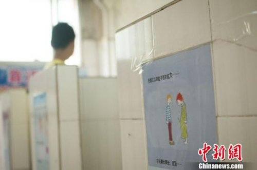 图为广西柳州文惠小学在男厕所悬挂的性知识绘本，图文并茂的讲述，给学生进行性教育。　黄威铭 摄