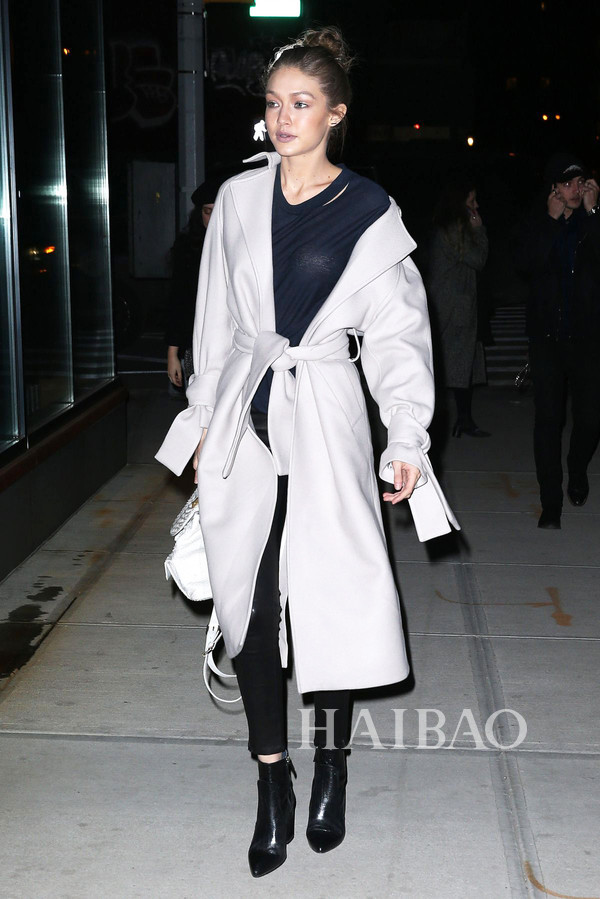 吉吉·哈迪德 (Gigi Hadid) 2017年2月13日纽约街拍，穿Topshop白色系带羊毛大衣搭配深色内搭简约有型，M2Malletier背包手提增加造型感。