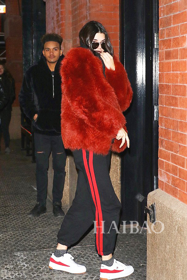 肯达尔·詹娜 (Kendall Jenner) 2017年2月16日纽约街拍，身穿皮草外套搭配维特萌 (Vetements) 两道杠运动裤与Gosha Rubchinkiy红白拼色运动鞋。