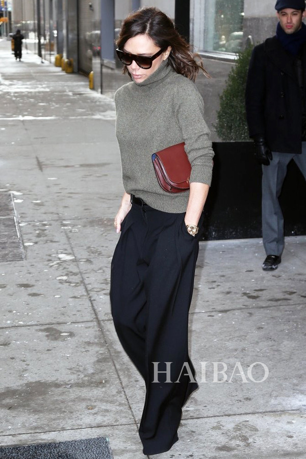 维多利亚·贝克汉姆 (Victoria Beckham) 在纽约外出。身穿灰绿色高领针织衫搭配阔腿裤和棕色手包，简约低调的质感很耐看。