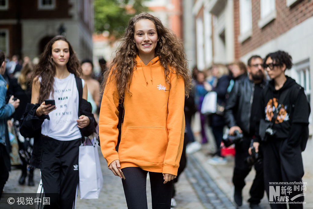 当地时间2017年9月16日，英国伦敦，2018春夏伦敦时装周：潮人街拍（9月16日）。***_***LONDON, ENGLAND - SEPTEMBER 16: Models wearing orange hoody outside Simone Rocha during London Fashion Week September 2017 on September 16, 2017 in London, England. (Photo by Christian Vierig/Getty Images)