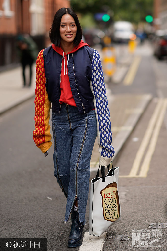 当地时间2017年9月16日，英国伦敦，2018春夏伦敦时装周：潮人街拍（9月16日）。***_***LONDON, ENGLAND - SEPTEMBER 16:  Tiffany Hsu wears a bomber jacket, a red hoodie, denim jeans, a Loewe bag with a printed toast, leather black boots, during London Fashion Week September 2017 on September 16, 2017 in London, England.  (Photo by Edward Berthelot/Getty Images)